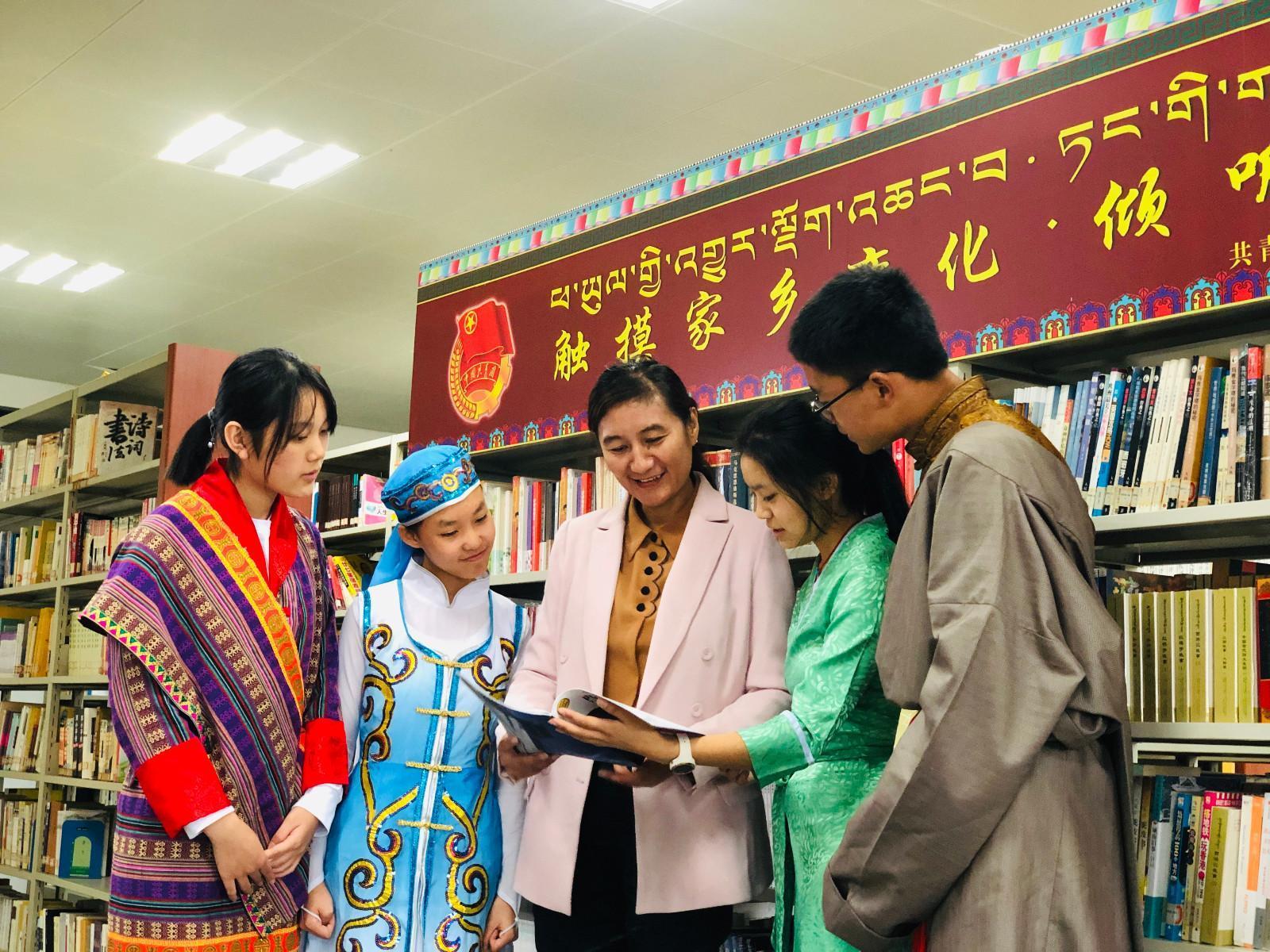 yj1123p02共青團西藏自治區(qū)委員會副書記格桑卓瑪，在武漢西藏中學設(shè)立“觸摸家鄉(xiāng)變化·傾聽黨的聲音”主題書刊欄處向?qū)W生們介紹相關(guān)書籍。.jpg